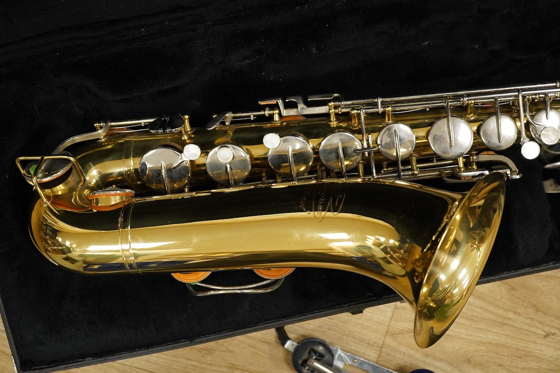A cased Buescher Aristocrat tenor saxophone and stand